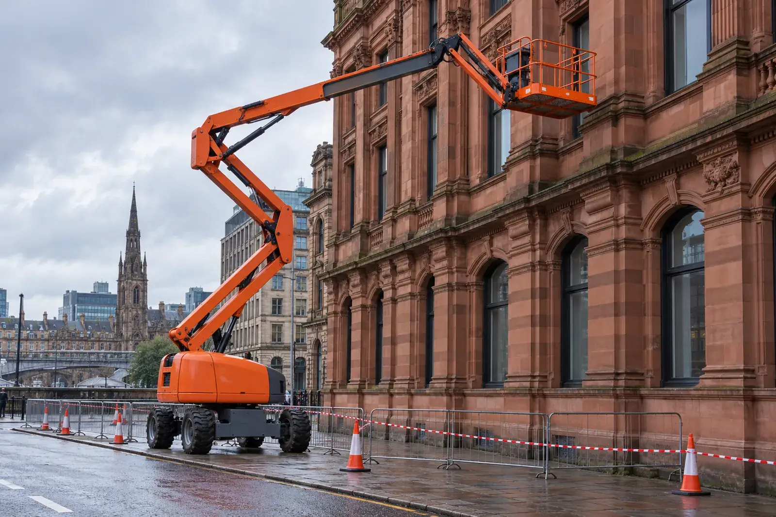 Articulated cherry picker beside a red sandstone commercial building